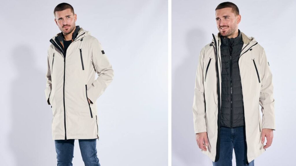 Beiger emilio adani Herrenparka mit Kapuze und Reißverschlüssen, kombiniert mit Jeans und dunkler Innenjacke.