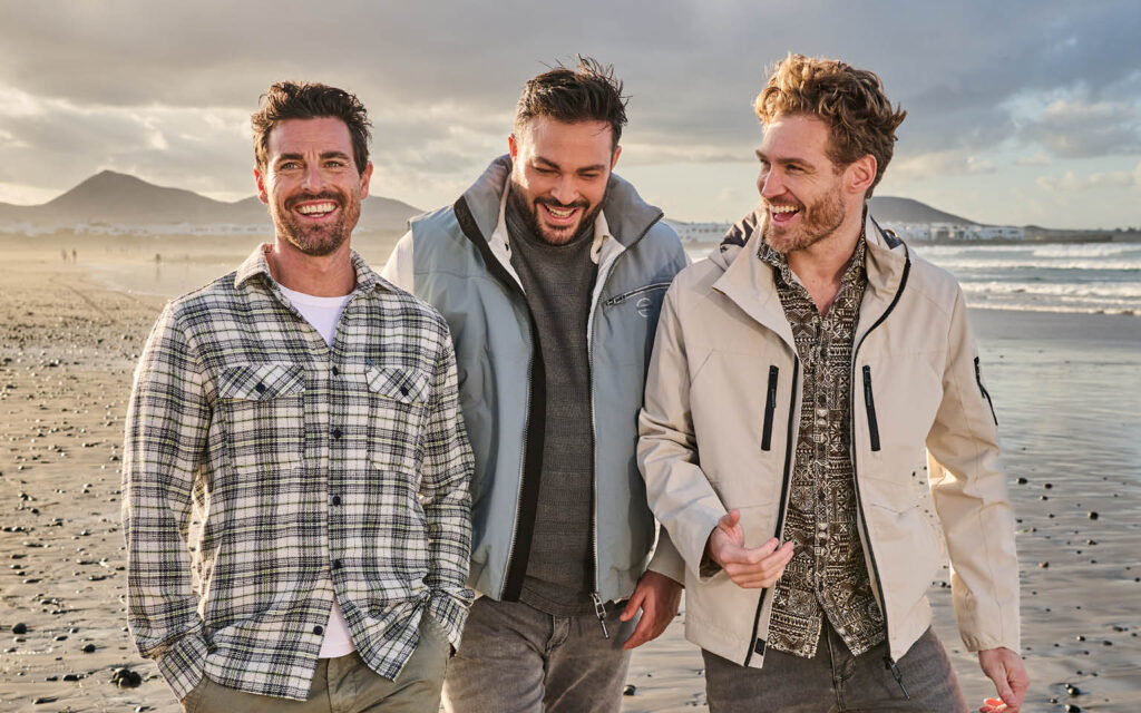 engbers Jubiläumskollektion am Strand Drei Männer tragen die engbers Jubiläumskollektion am Strand.