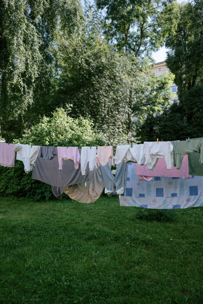 Wäscheleine mit Kleidung Wäsche hängt auf einer Leine in einem grünen Garten zum Trocknen.